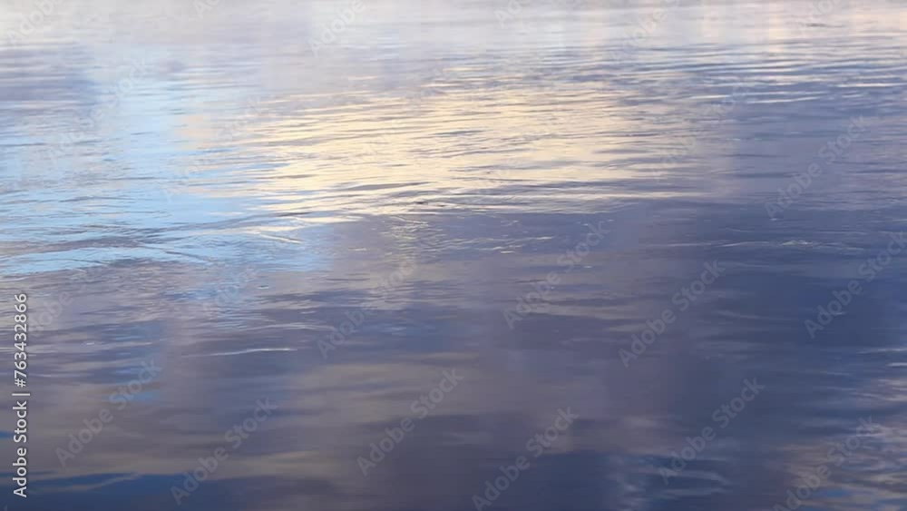 Reflection of clouds in water. The surface of water in a lake, river or flooded quarry. Ripples on the water. Beautiful color of water. Natural background Reflection of clouds in water. The surface of water in a lake, river or flooded quarry. Ripples on the water. Beautiful color of water. Natural background
