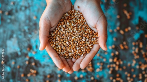 A person holds a handful of buckwheat seeds in their hands, showcasing the nutritious and versatile ingredient © Breezze