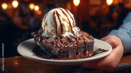 Obraz na płótnie A picture of a person savoring a gooey, chocolatey brownie topped with vanilla ice cream, the ultimate dessert. w salonie