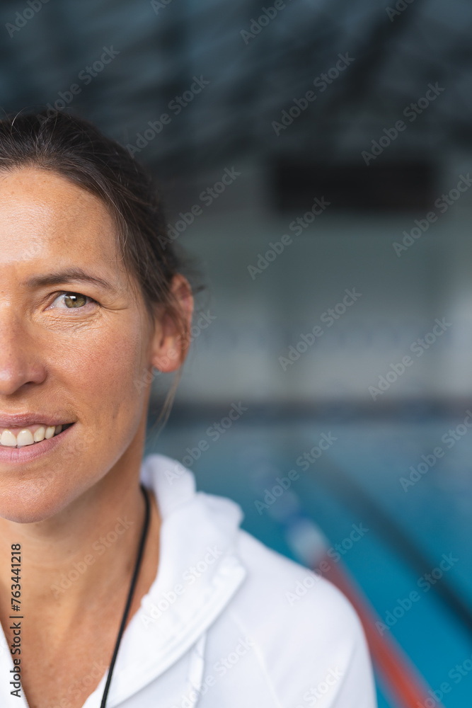 A middle-aged Caucasian woman stands before a pool, blue background with copy space A middle-aged Caucasian woman stands before a pool, blue background with copy space