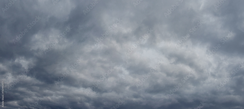 Fototapeta premium The dark stormy sky is covered with dense gray clouds