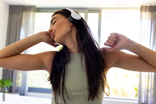 A young Asian brunette woman enjoys a break with music at home