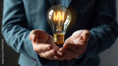 Close-up shot of a businessman's hands holding a futuristic light bulb, symbolizing the visionary approach to business powered by advanced technology