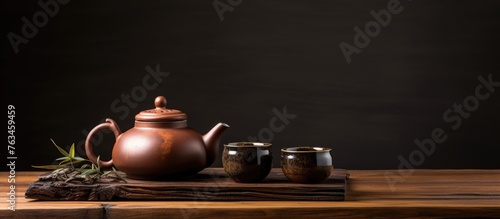 A teapot and cups on a wooden table