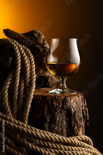 Brandy snifter and rope on a old stumb. photo