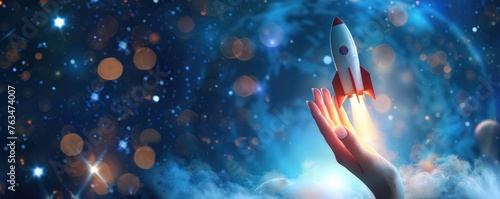 toy rocket being launched from a hand against a starry and nebulous space background photo