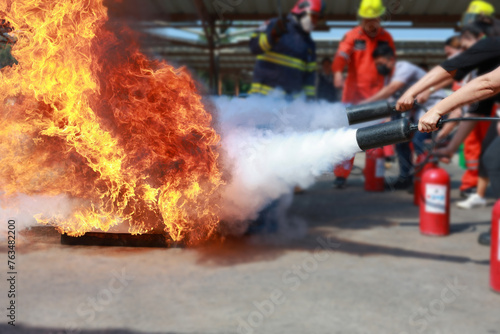 Employees firefighting training, Concept Employees hand using fire extinguisher fighting fire closeup. Spray fire extinguisher.	
