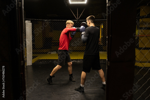 Two professional boxer boxing in dark gym. Boxer training concept.