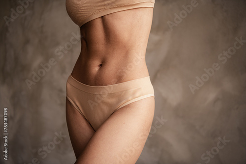 Cropped photo of charming sportswoman advertising fashion collection casual lingerie isolated on grey concrete wall background