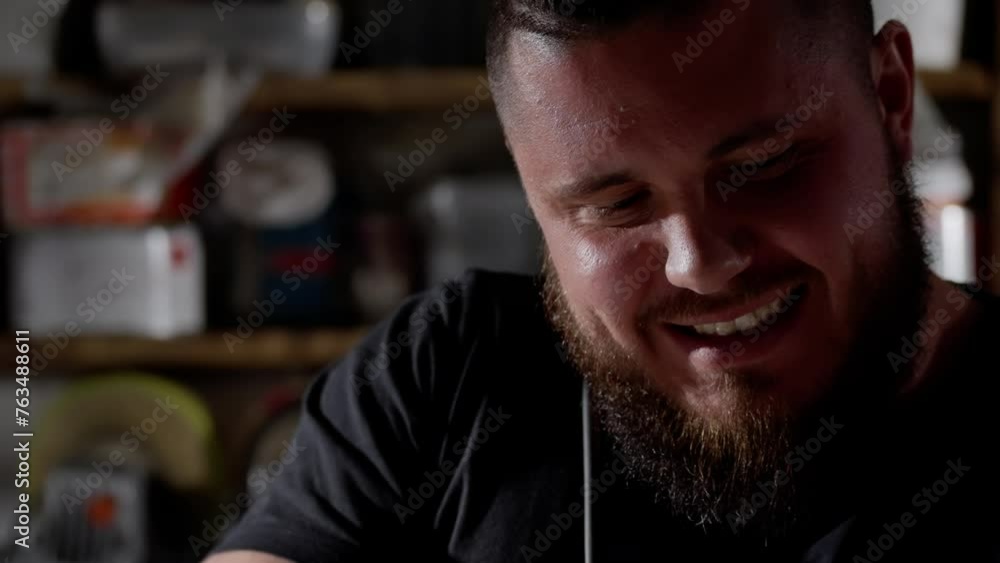 Smiling bearded man in a casual black t-shirt enjoying a moment of leisure with a blurred background Smiling bearded man in a casual black t-shirt enjoying a moment of leisure with a blurred background
