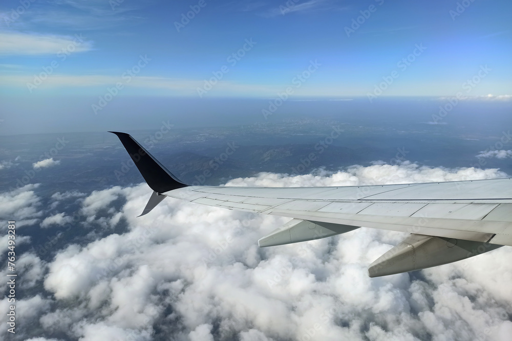 View through airplane window of commercial jet plane wing flying high in the sky. Air travelling concept View through airplane window of commercial jet plane wing flying high in the sky. Air travelling concept