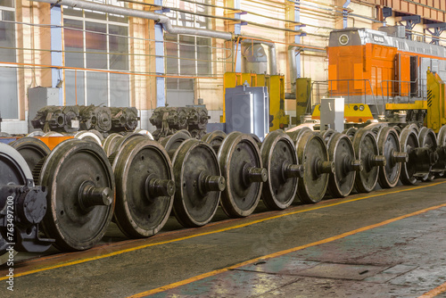 Row of steel wagon train wheels in a repair depot. Wheels of train in service industrial hall.