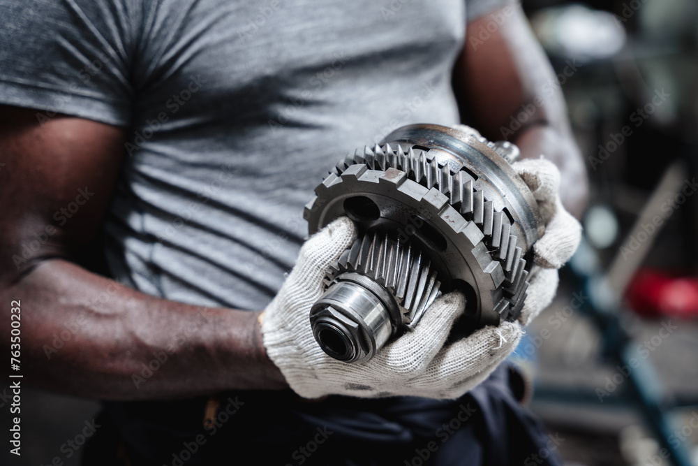 A man is holding a gear in his hand