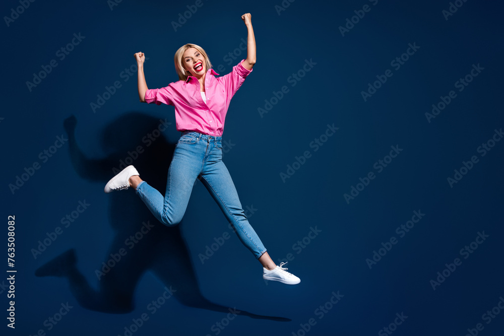 Fototapeta premium Full size photo of pretty young girl jump celebrate champion raise fists wear trendy pink outfit isolated on dark blue color background