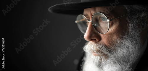 portrait of an old jewish man or rabbi with long beard and hat, glasses