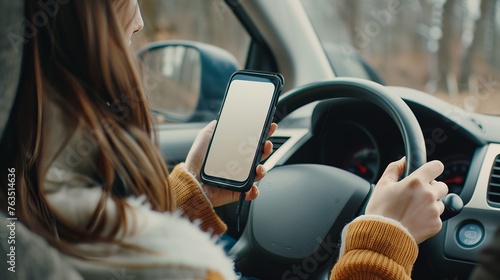 Woman looking on smartphone white screen and driving a car.