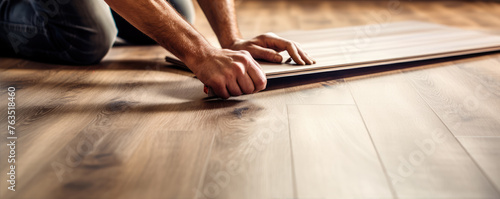 Worker installing laminate floor detail. House renovation with wooden designs © Michal