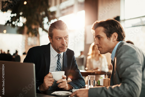 Two businessmen having a meeting at a indoor cafe and having a discussion