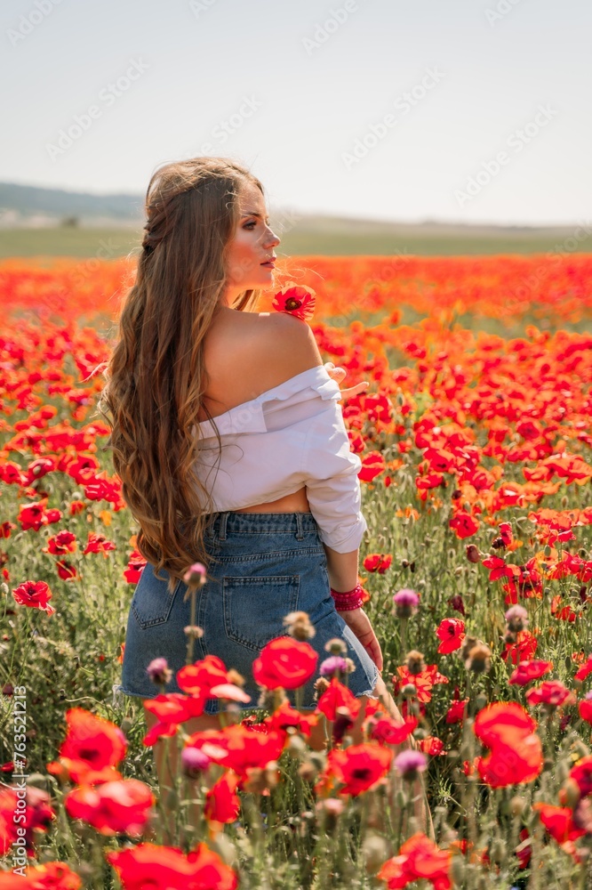 Woman poppies field. Side view of a happy woman with long hair in a poppy field and enjoying the beauty of nature in a warm summer day. Woman poppies field. Side view of a happy woman with long hair in a poppy field and enjoying the beauty of nature in a warm summer day.