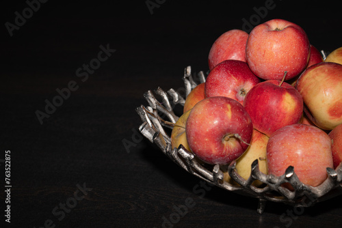 Apples in a vase on black background with space for text