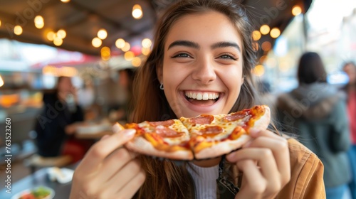 Young happy woman eating pizza on a food court background.