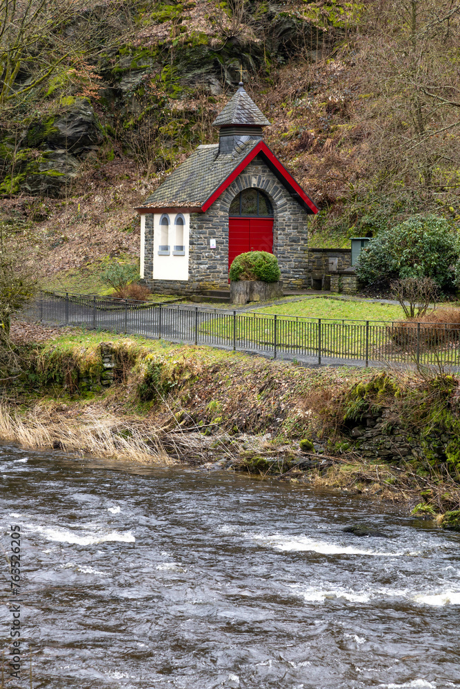 Monschau, Germany. 19 february 2024. A small church with red doors along the wild river in Monschau in autumn. Monschau, Germany. 19 february 2024. A small church with red doors along the wild river in Monschau in autumn.