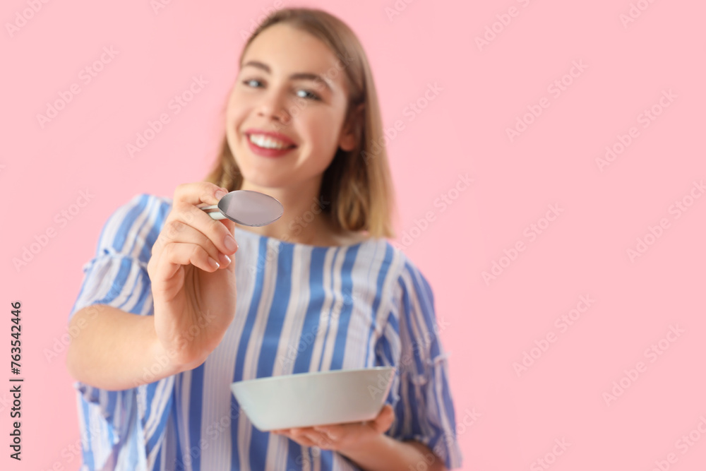 Young woman with spoon and bowl on pink background, closeup Young woman with spoon and bowl on pink background, closeup