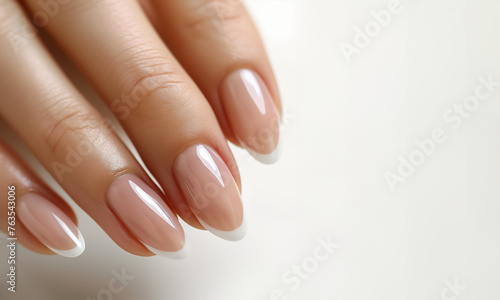 Close-up french manicure on a white background. Well-groomed female hands. Healthy nail enamel.