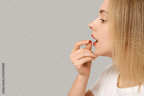 Young woman taking vitamin ...