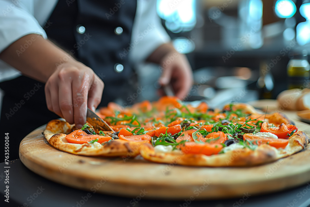 Chef is preparing pizza with tomatoes in the restaurant kitchen, close up