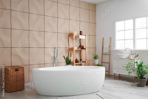 Stylish interior of bathroom with houseplants and cosmetic products