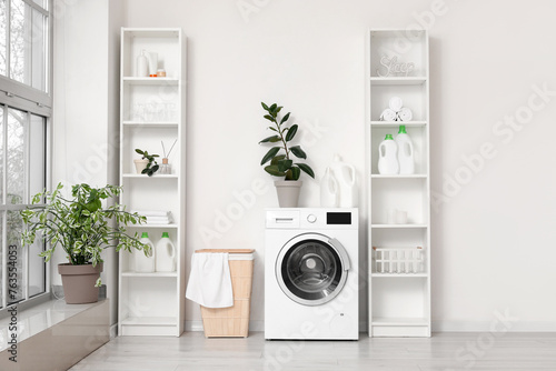 Schilderij op canvas Modern washing machine with basket and shelving units near white wall