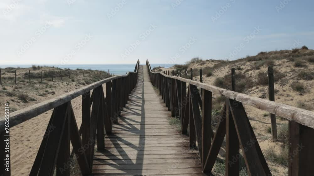 Eco tourism walkway wooden road brown fences sun shines shadow make pattern, blue sky white clouds in background. Eco tourism walkway wooden road brown fences sun shines shadow make pattern, blue sky white clouds in background.