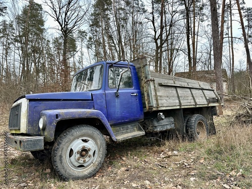 Truck against a background of trees. Old truck in the forest. Broken truck in the open air.
