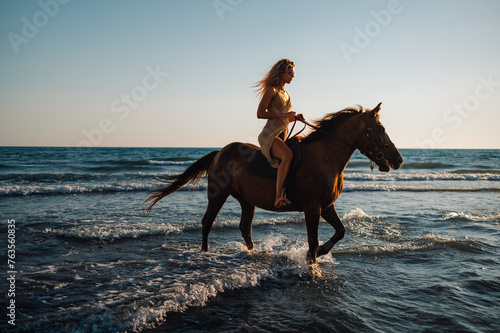 A young attractive woman is horseback riding at seaside.