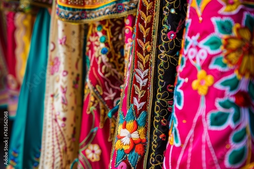 Variety of vibrant traditional dresses with intricate embroidery hanging on display rack