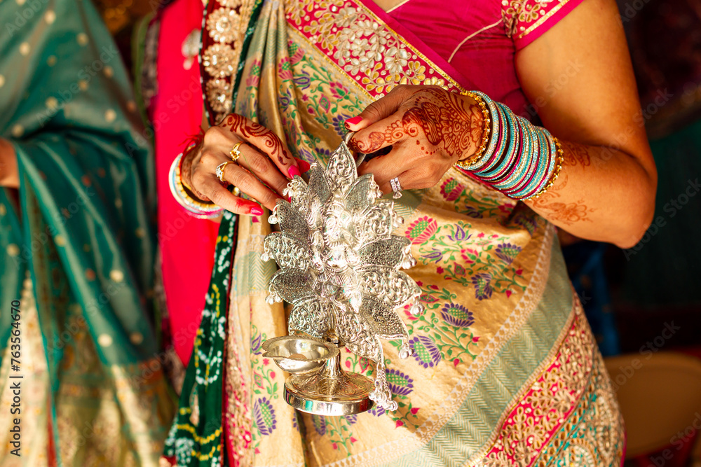 Naklejka premium Woman in Indian Sari holds ceremonial decor
