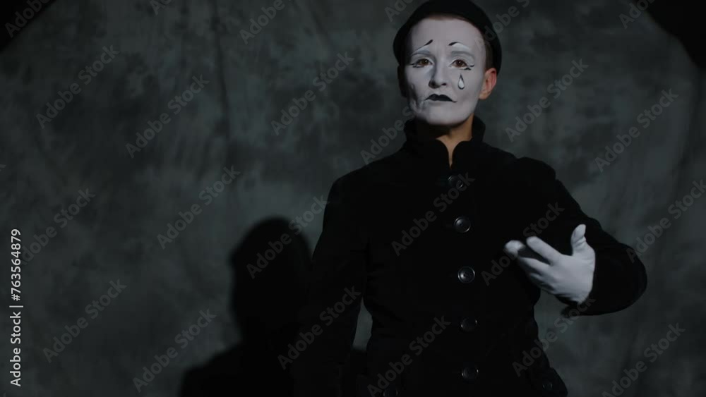 Vertical tilt shot of creative female mime performer using colorful ...