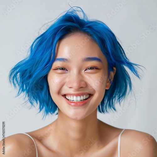 Dive into the sapphire radiance of this skincare portrait featuring a delighted 20-year-old Asian model showcasing blue hair. Against a soft backdrop