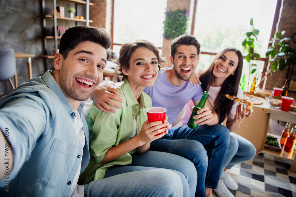 Photo of idyllic positive buddies sitting couch hug drink beer eat pizza make selfie daylight house indoors