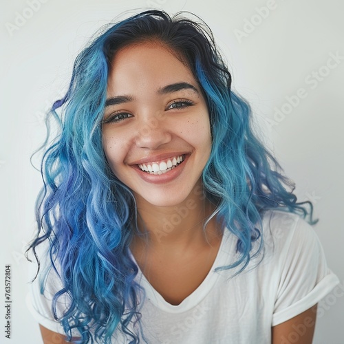 Embrace the cerulean beauty in this skincare portrait of a joyful 20-year-old Latina model showcasing blue hair. Against a soft backdrop, with a luminous filter effect and ambient studio lighting