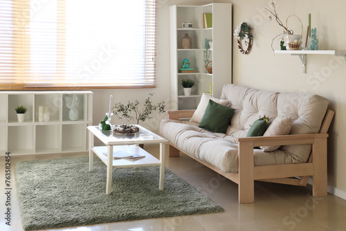 Interior of living room with sofa, shelf units and Easter decor © Pixel-Shot
