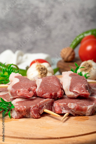 Lamb sirloin. Lamb sirloin meat skewered on a wooden serving board. Close up