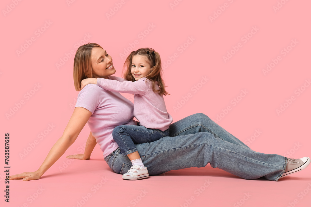 Little girl and her mother spending time together on pink background. Mother's Day Little girl and her mother spending time together on pink background. Mother's Day