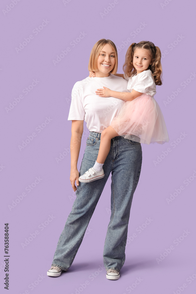 Portrait of young mother and her daughter on lilac background. Mother's Day Portrait of young mother and her daughter on lilac background. Mother's Day