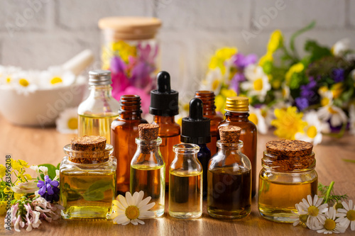 Obraz na płótnie Concept of alternative herbal medicine. Bottles of tincture or potion, organic essential oils, dry healthy herbs, floral extracts on wooden table. Pure natural ingredients for cosmetic production w salonie