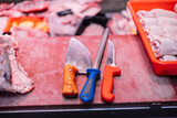 closeup Two Butcher Knives and Knife Sharpener on Meat Cutting Board in Butcher Shop