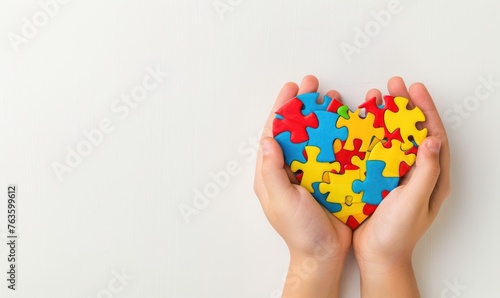 Child hands holding heart shaped colorful puzzle