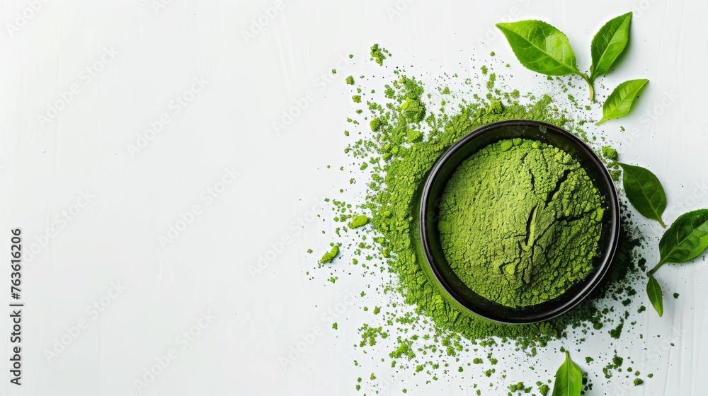 This image shows a bowl of organic matcha green tea powder with green tea leaves on a white background. The powder is a bright green color and has a smooth, fine texture. - obrazy, fototapety, plakaty 