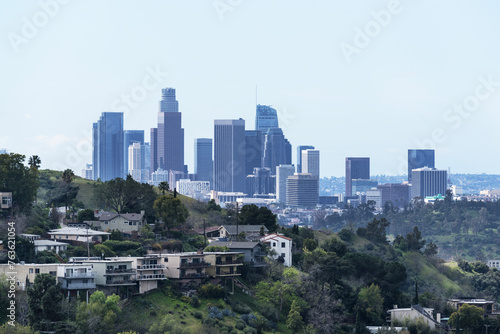 Downtown Los Angeles skyline towers with hillside homes in foreground.